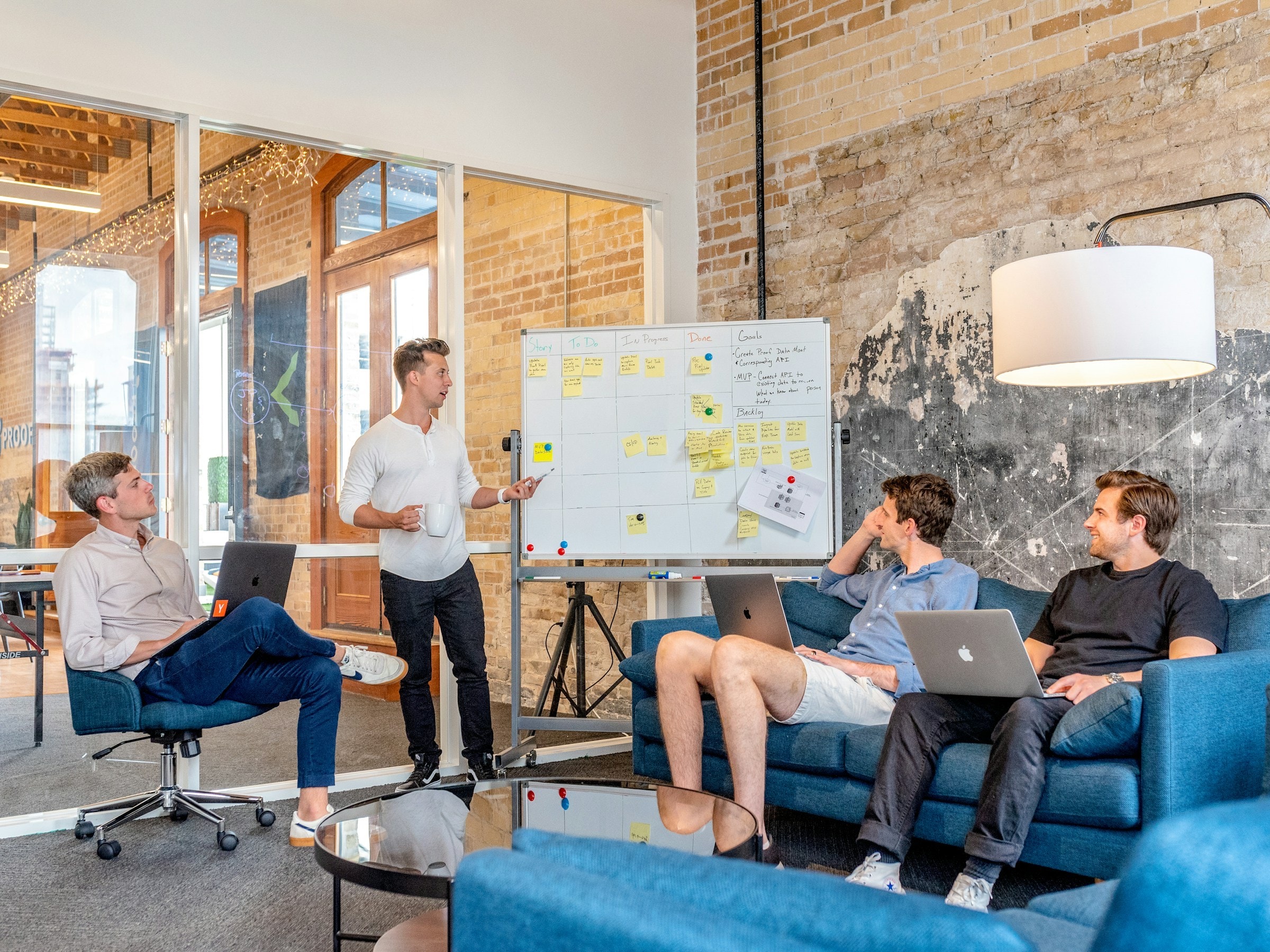 A consultant leading a planning workshop at a whiteboard of sticky notes